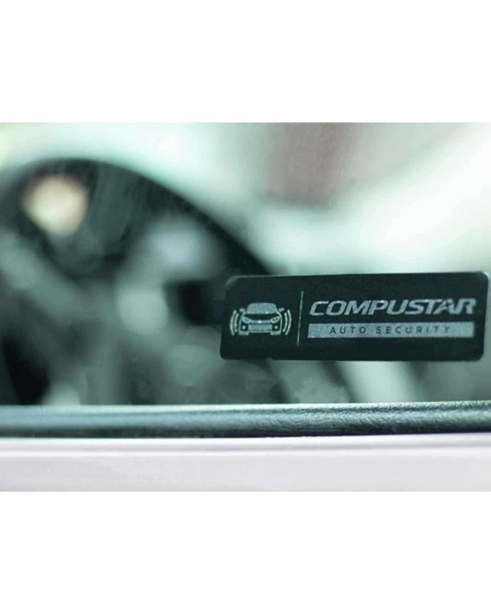Compustar auto security sticker on a vehicle window after install